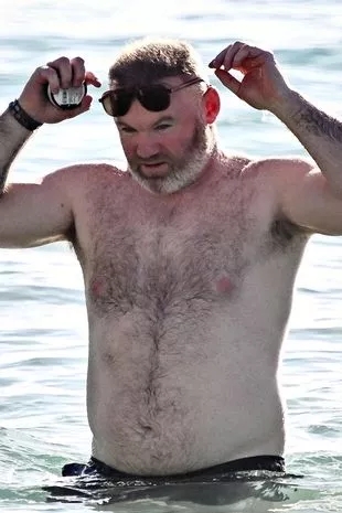 鲁小胖😂镜报：鲁尼度假被拍到挺着大肚腩，太太科琳身着比基尼